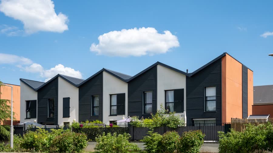 Maisons neuves alignées sous un ciel bleu, un logement neuf finançable au prêt à taux zéro